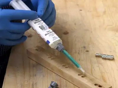 Нанесення **епоксидного клею** WEICON Epoxy Minute Adhesive у **свердлильні отвори** дерев'яної заготовки за допомогою **змішувальної (дисперсійної) насадки**. Фіксація магнітів для DIY-тримача ножів.