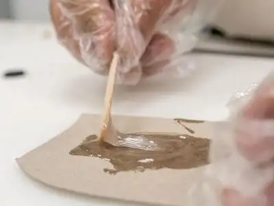 Крупний план: процес **змішування двох компонентів** епоксидного клею WEICON Epoxy Minute Adhesive **дерев'яною паличкою**. Етап підготовки до **приклеювання магнітів** у DIY-тримачі для ножів.