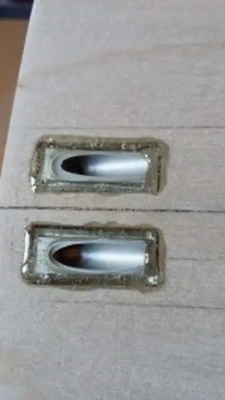 Два виходи гребного вала, залиті епоксидним клеєм Weicon Epoxy Minute Adhesive у корпусі моделі катера, до зачистки та вирівнювання поверхні.