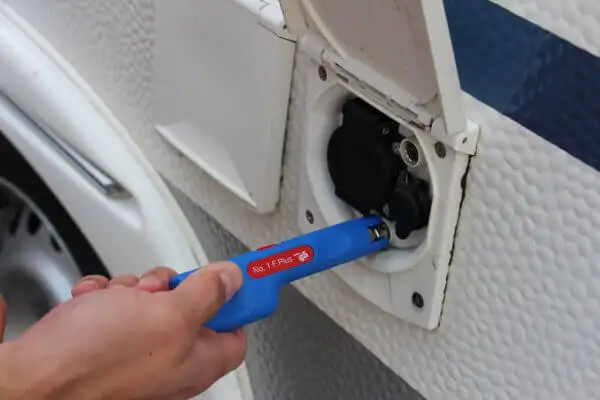Рука використовує інструмент Weicon Tools Coax-Stripper No 1 F Plus для швидкого зняття ізоляції та монтажу/демонтажу F-роз'ємів коаксіальних кабелів зовнішнього входу кемпера