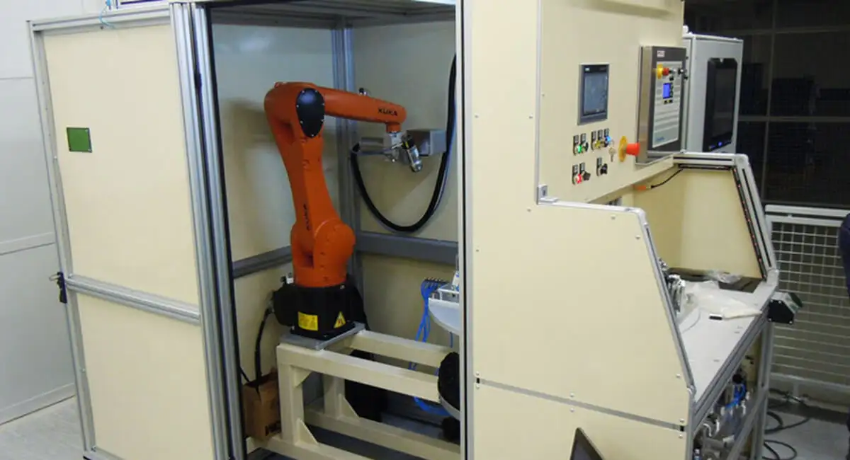 Промисловий роботизований комплекс (кобот KUKA) у захисному боксі, оснащений пневматичною дюзою, що використовує ефект Коанда, для автоматизованого обдуву або очищення деталей