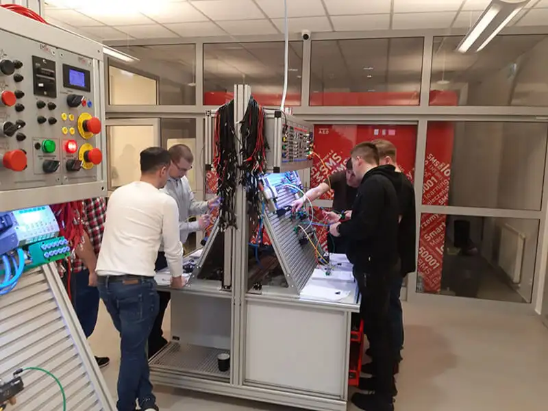 Група студентів працює з професійними навчальними наборами для вивчення пневматики та систем автоматизації