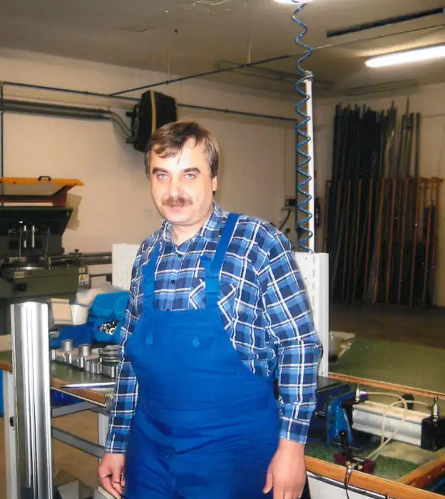 Avtomatyzatsiia chastyny vyrobnychykh protsesiv mashynamy CNC Працівник у виробничому цеху стоїть біля обладнання CNC та деталей для обробки металу